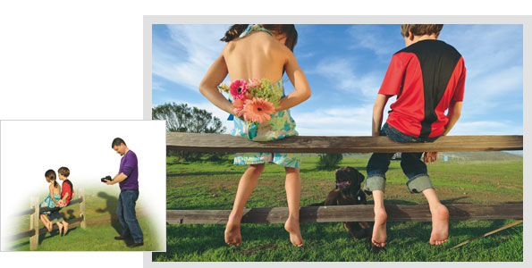 목장의 나무 펜스위에 걸터 앉은 남자아이와 여자아이. 여자아이는 뒤짐으로 꽃을 들고 있는 사진
